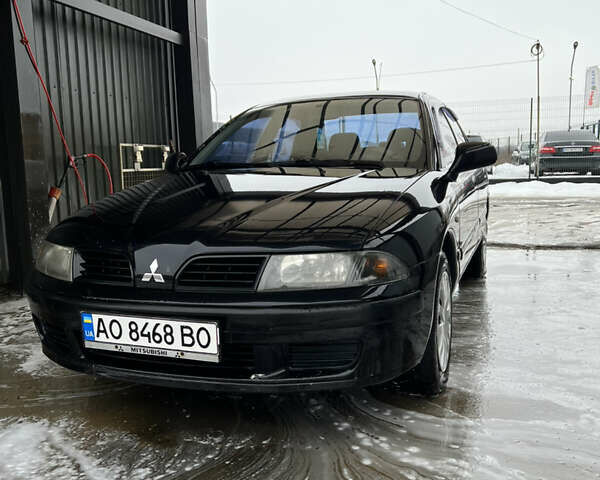 Черный Мицубиси Харизма, объемом двигателя 1.6 л и пробегом 300 тыс. км за 3100 $, фото 1 на Automoto.ua