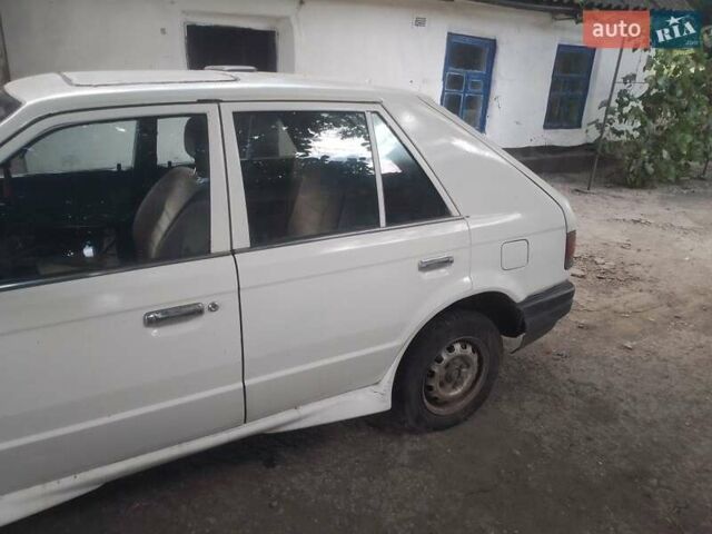 Белый Мазда 323, объемом двигателя 1 л и пробегом 250 тыс. км за 600 $, фото 1 на Automoto.ua